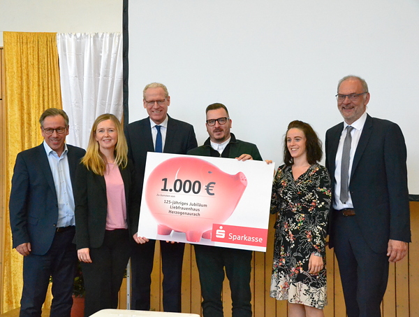 Landrat Alexander Tritthart, Frau Böskens und 1. Bürgermeister German Hacker überreichen einen Scheck zum Jubiläum.