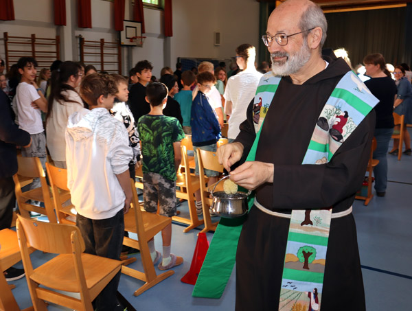 Präses Br. Marinus Parzinger segnet die frisch renovierte Turnhalle mit Weihwasser.