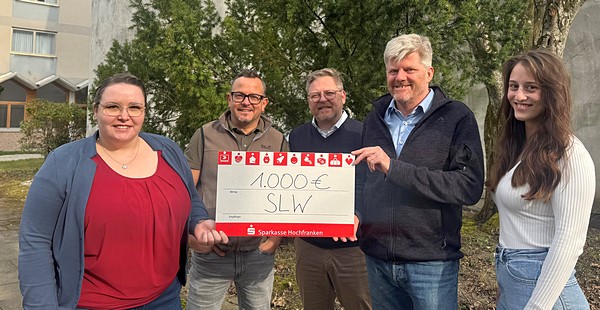 Gruppenbild mit fünf Personen und einem symbolischen Spendenscheck