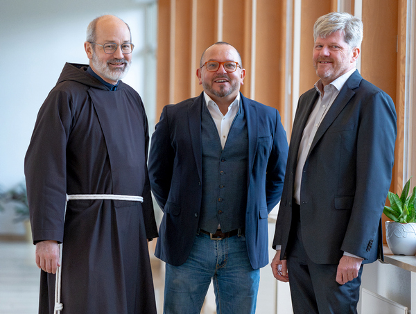 Gruppenbild mit drei Männern, die im Flur stehen