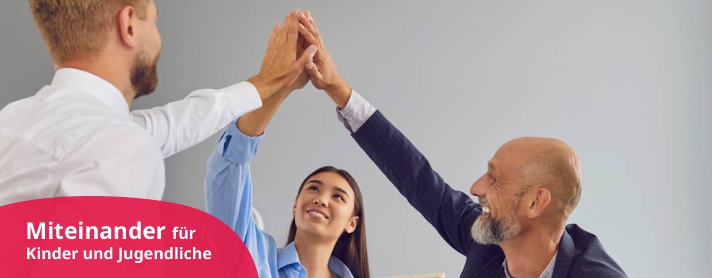 Drei Personen im Büro geben sich ein "High Five"