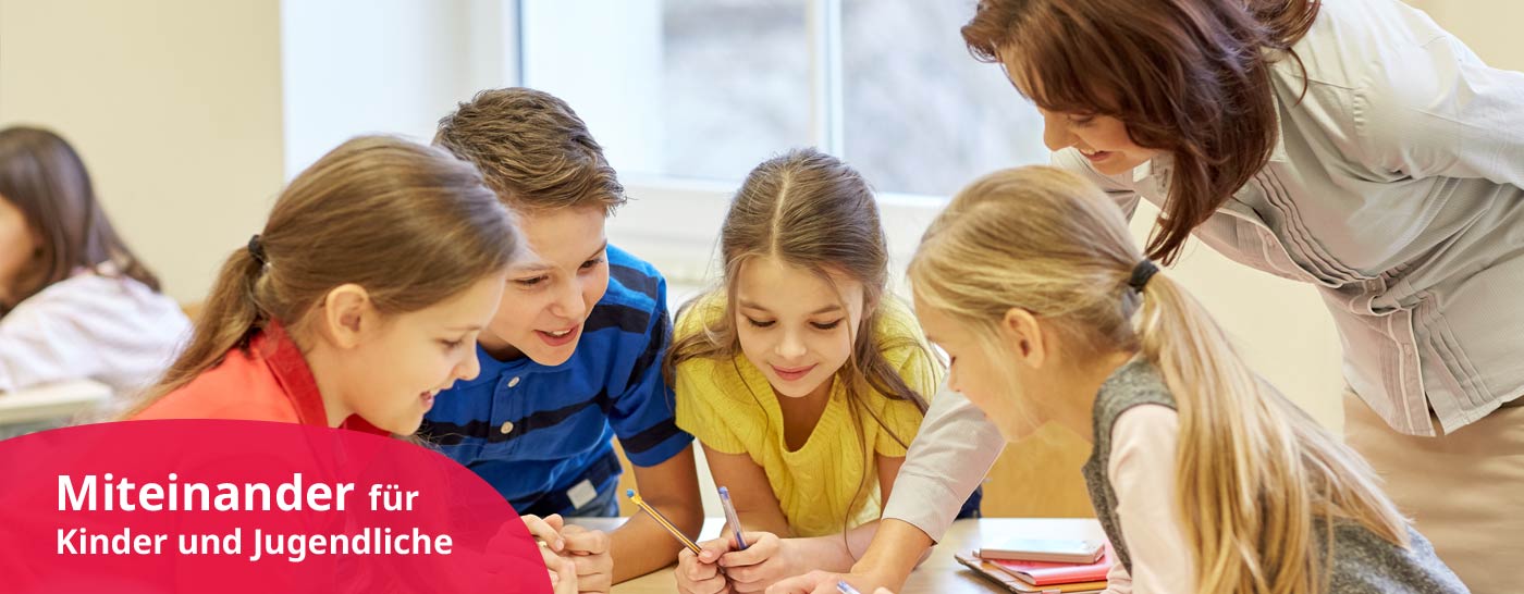 Pädagogin unterstützt Schulkinder bei Aufgaben