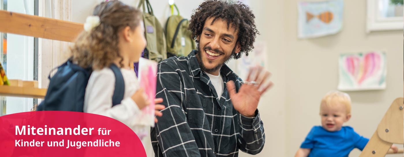 erzieher winkt kindergartenkind