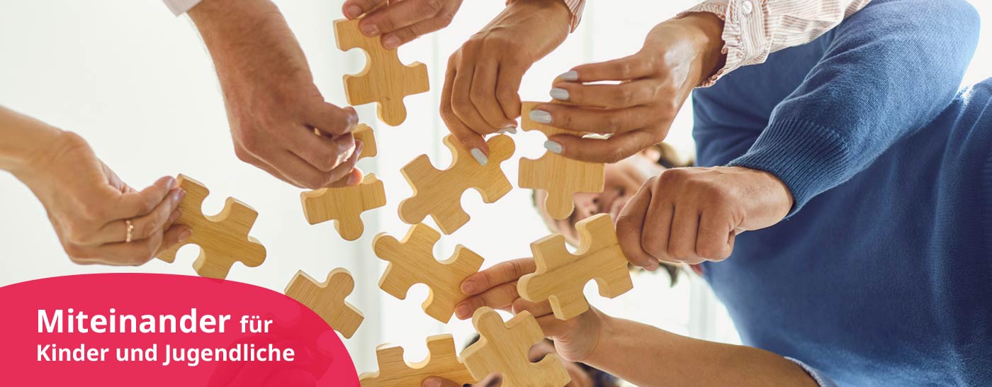 Hände fügen Puzzlestücke zusammen