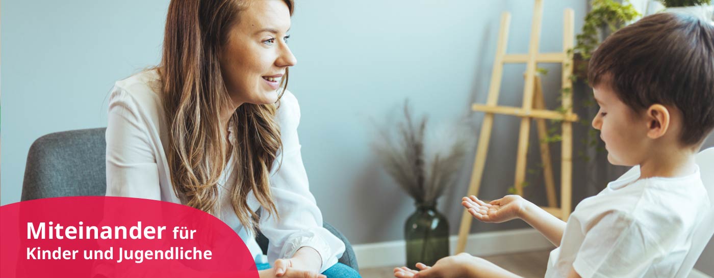 Psycholog/in (m/w/d) im Franziskushaus Altötting redet mit Kind in heilpädagogischer Wohngruppe