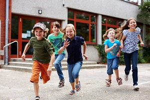Schulkinder kommen aus der Schule und rennen zum Hort