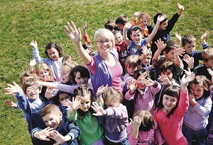 Kinder und Erzieherin winken dem Fotografen zu