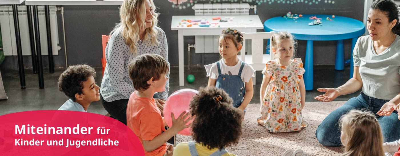 Kindergartenkinder sitzen in einem Kreis